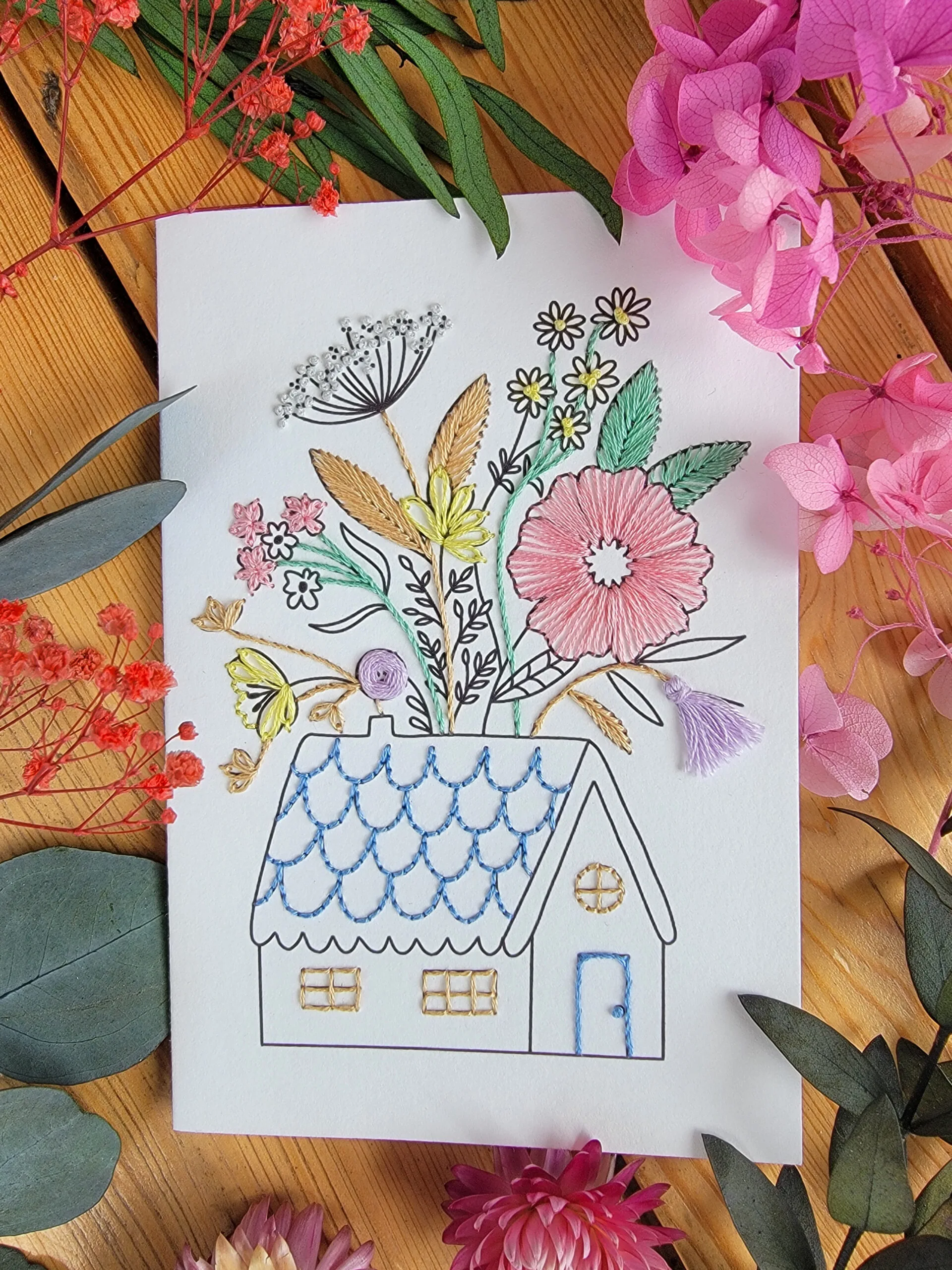 Carte à broder représentant une maison de campagne dont le toit se fleurit